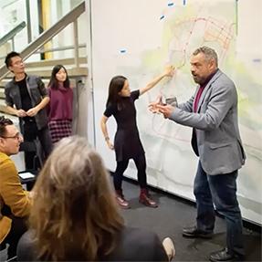 An instructor and a student gesturing during a critique