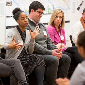 Three people in frame with a woman talking