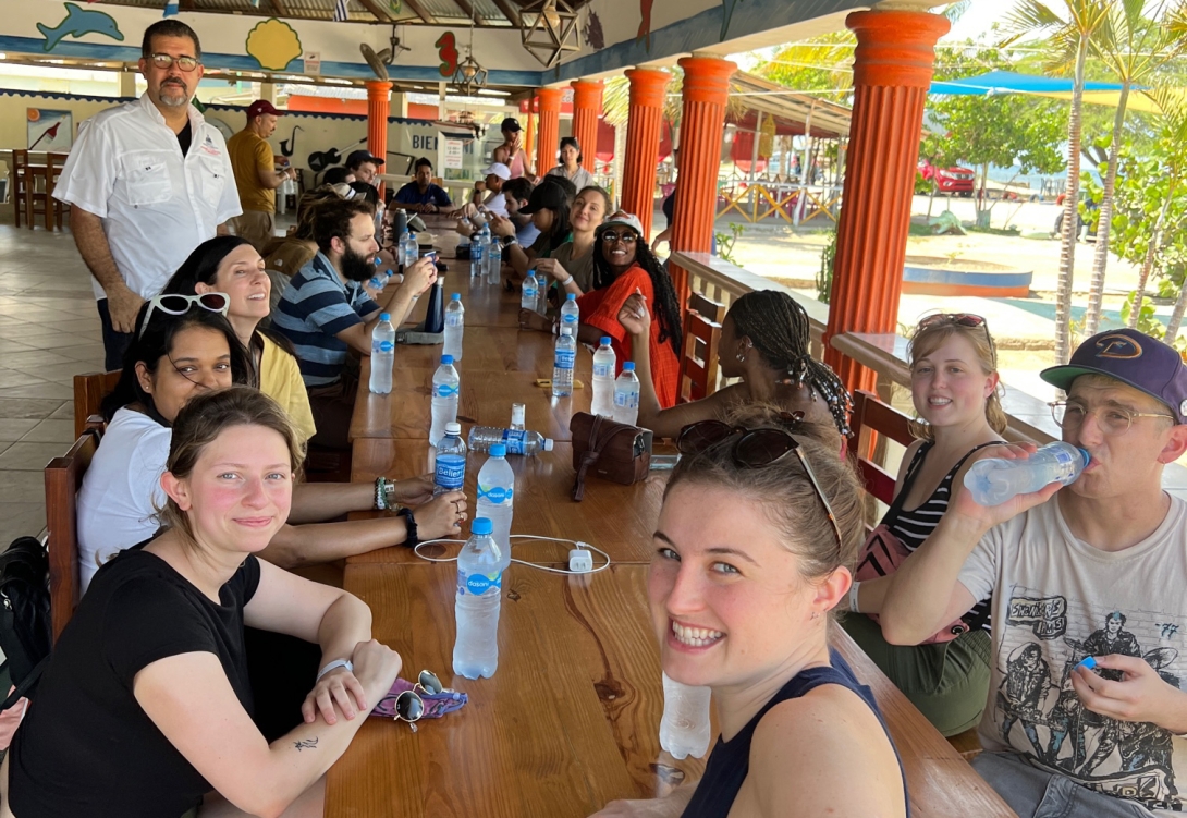 Group of young people seated at an open-air table with water bottles 