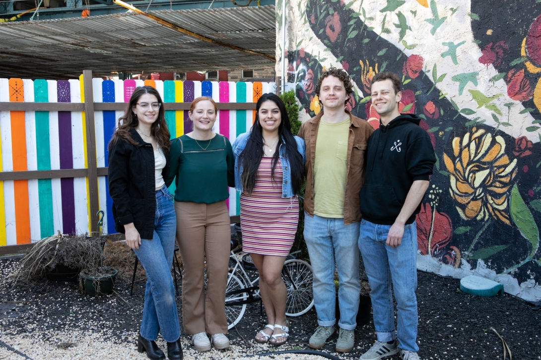 Group of five young people standing outdoors