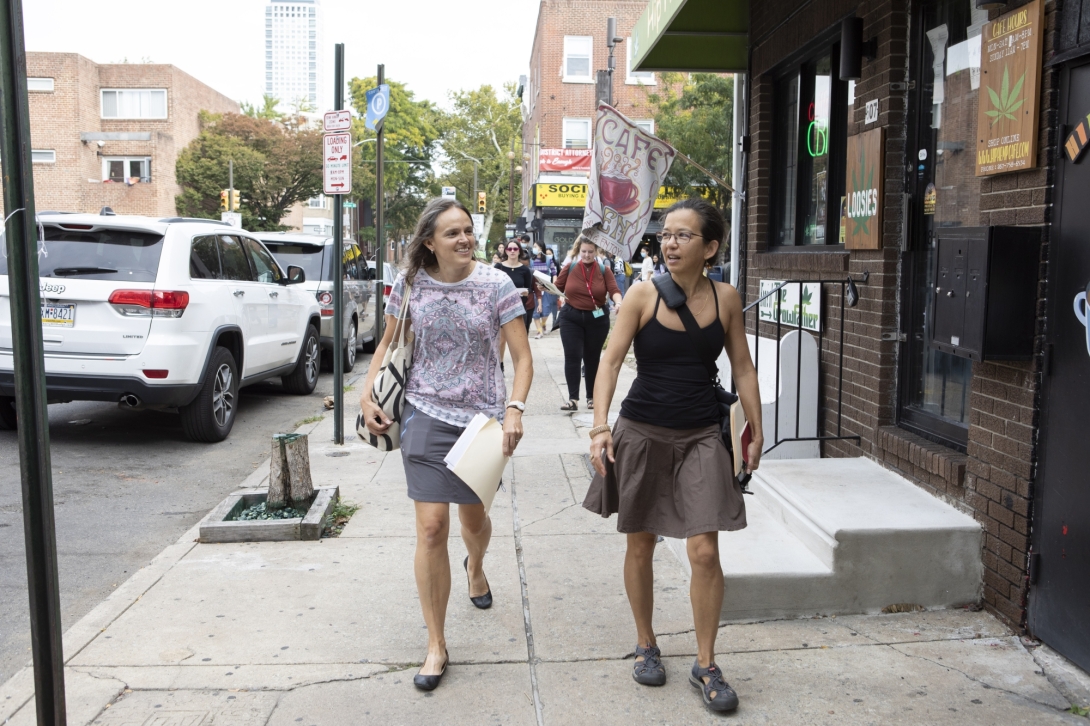 Two women lead a group of young adults on an urban walking tour 