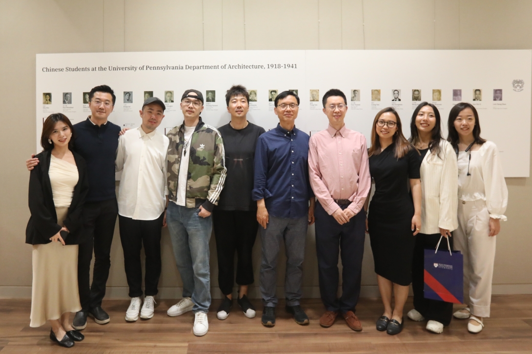 Group of Asian people of all ages in front of wall mural