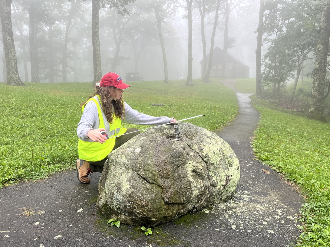 A person measure a rock waterfountain