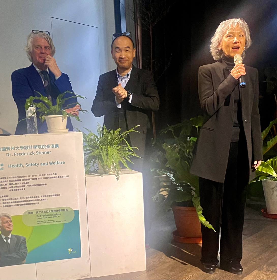 Three people stand next to podium