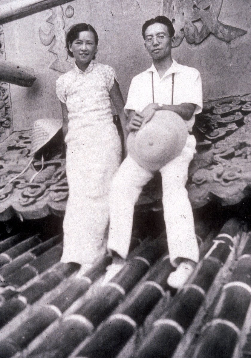 Two people stand on tile roof