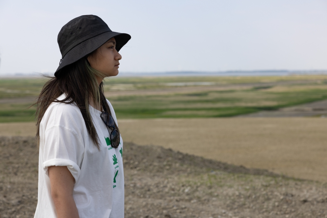 Young woman in hat outdoors looks into distance