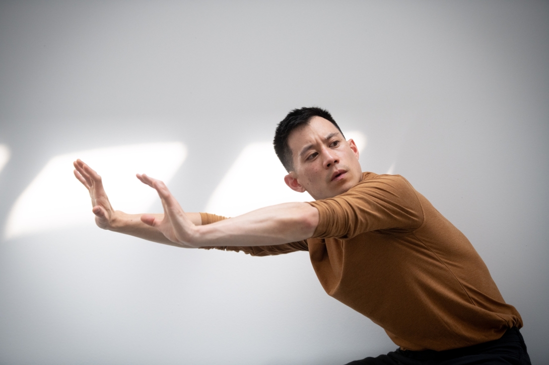Vu with arms extended to his right