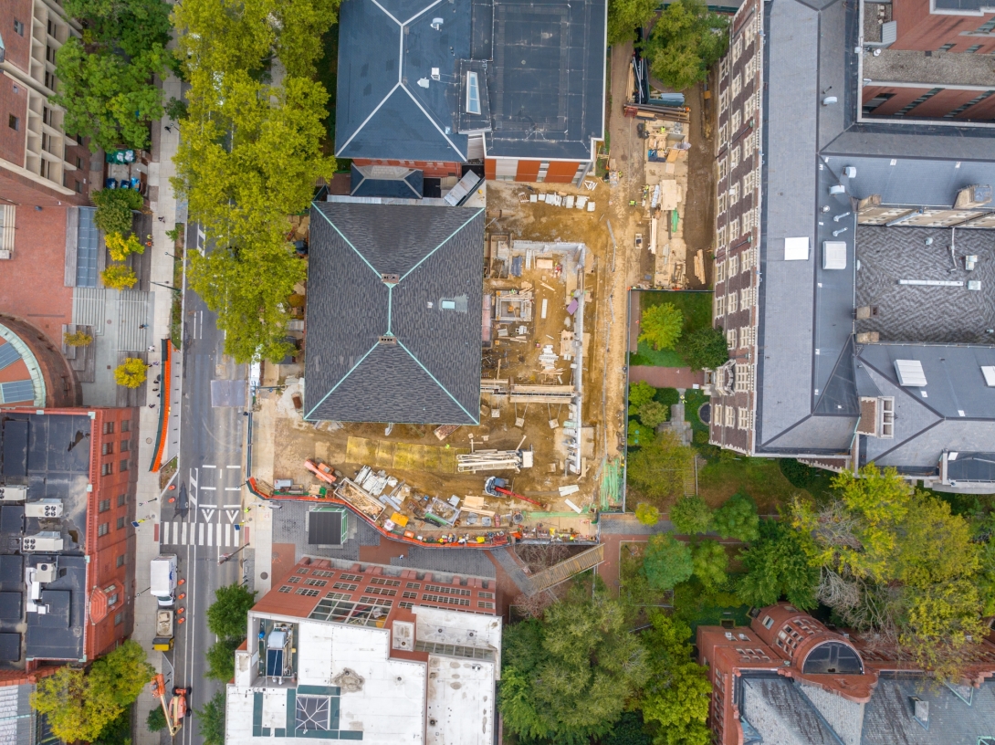 Aerial view of construction site with street at left and other buildings circling site