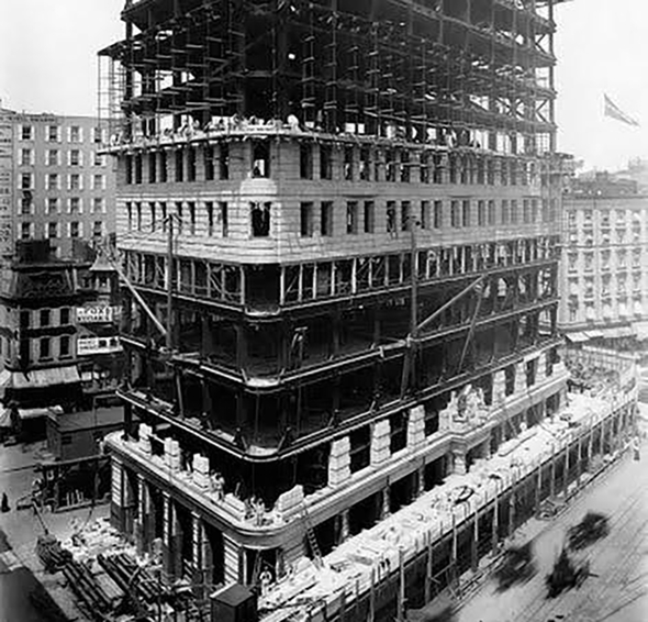 Historic photo of a large building with stone facade under construction