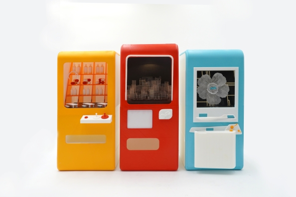 The artifacts are presented through a vending machine—a format that is distinctly Japanese. Inside the display window, abstract representations of scenes from the story are shown, such as a hospital bed, dining space, and urban environment.