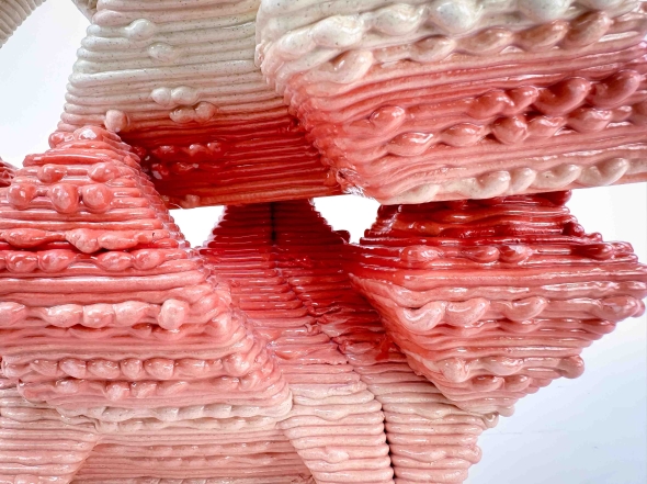 Close-up of a singular clay brick dyed red emphasizing texture.