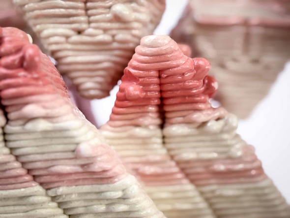 Close-up of a singular clay brick dyed red emphasizing color gradient.