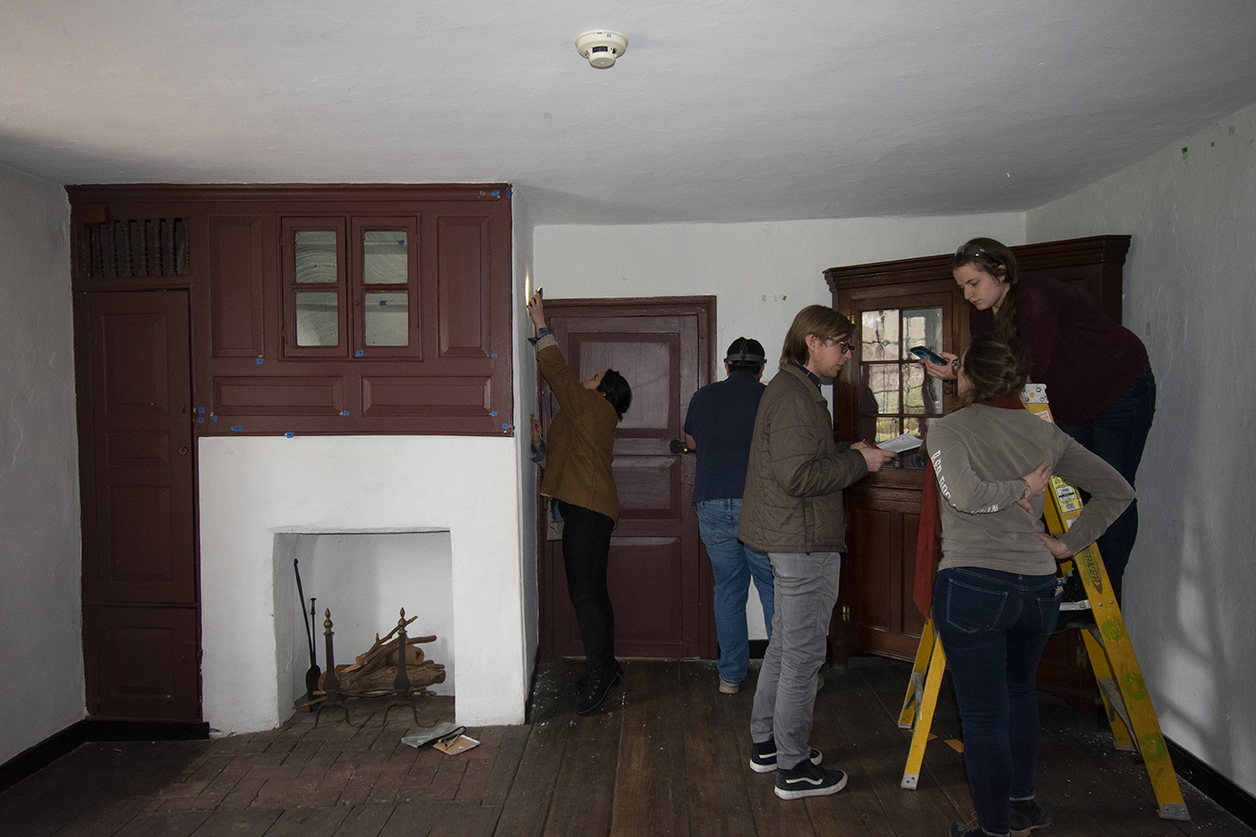 Room of historic house with several students examining it