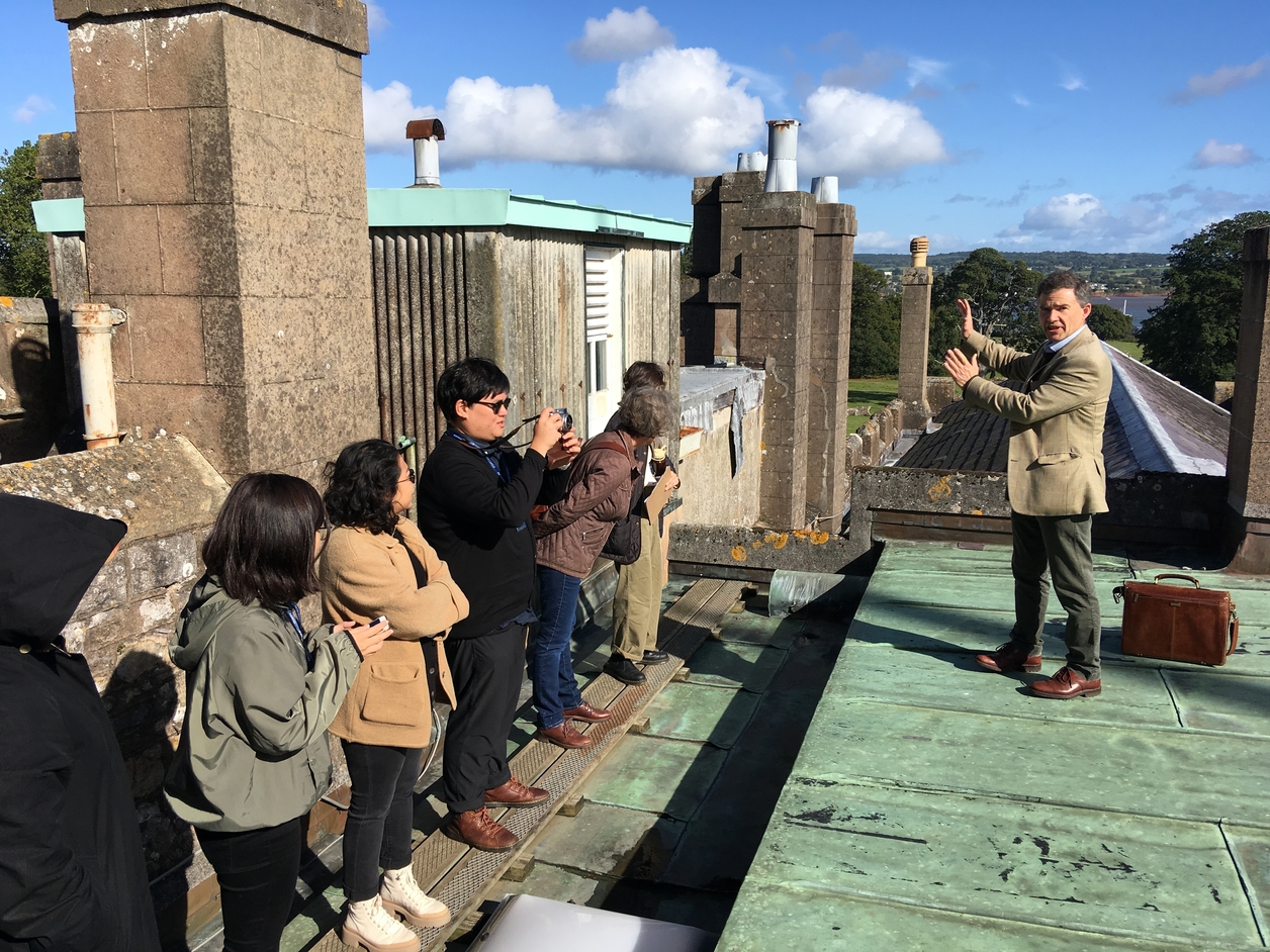 Students examining the roof of a historic house