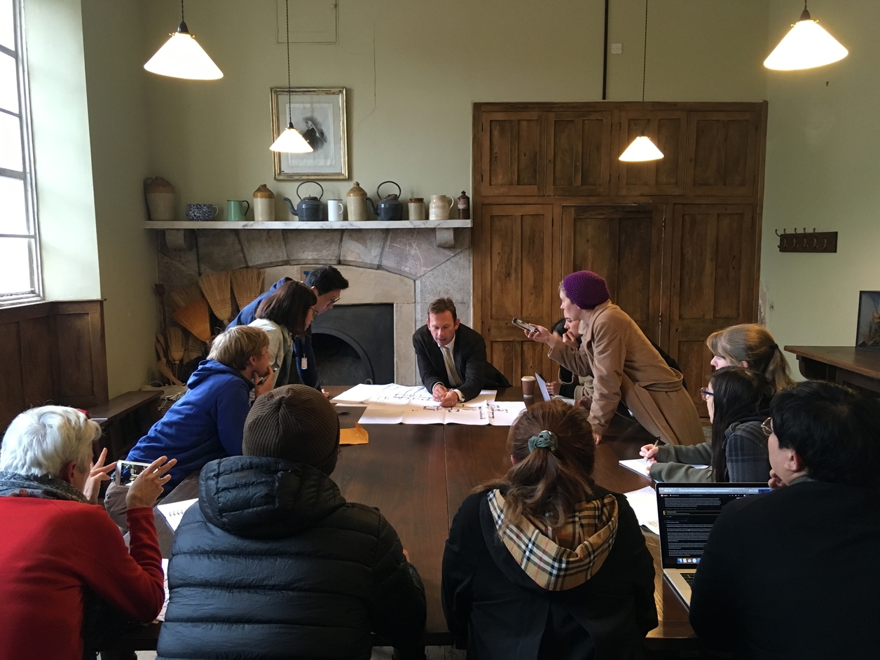 Students sitting around a large table examining a document together