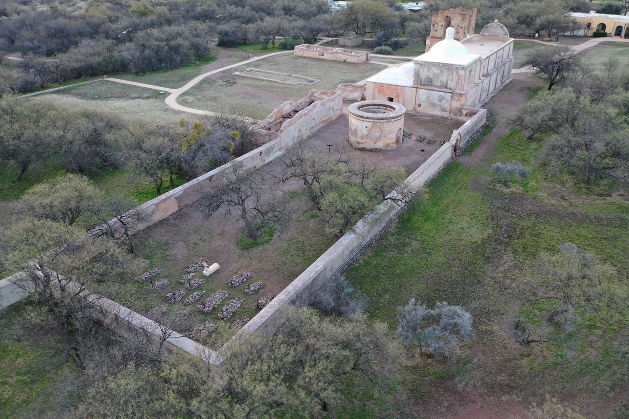 Arial view of concrete building with walled area with trees