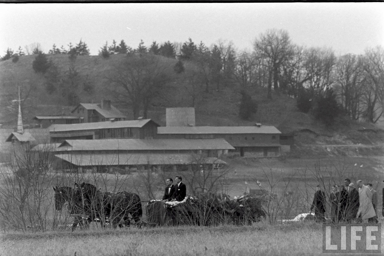 B/W photo of men in horse drawn carriage near farm